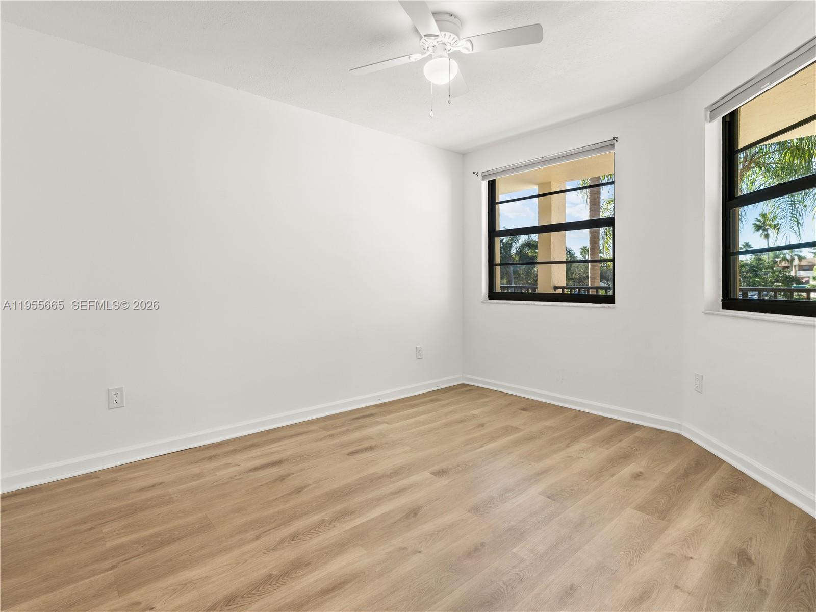 7547 Fairfax Drive, Unit 210 Tamarac, FL 33321 - Photo 15 of 38 an empty room with wooden floor fan and windows