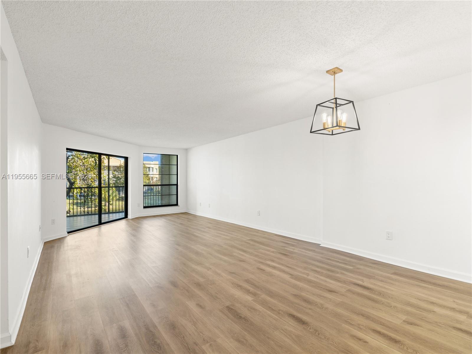 7547 Fairfax Drive, Unit 210 Tamarac, FL 33321 - Photo 2 of 38 a view of a room with wooden floor and window