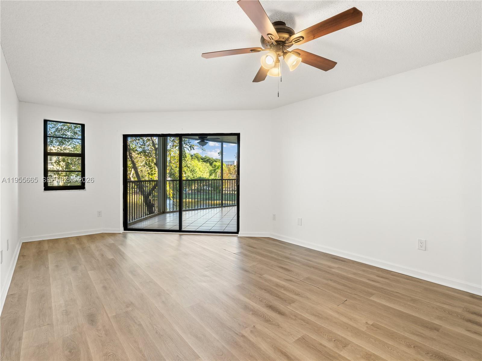 7547 Fairfax Drive, Unit 210 Tamarac, FL 33321 - Photo 4 of 38 wooden floor in an empty room with a window