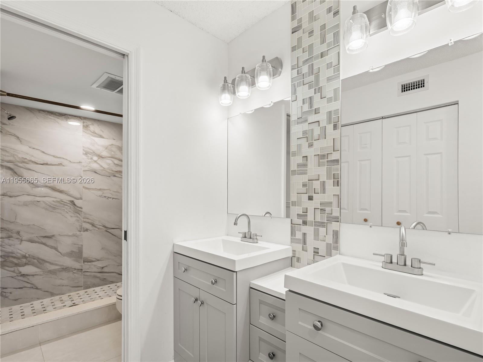 7547 Fairfax Drive, Unit 210 Tamarac, FL 33321 - Photo 5 of 38 a bathroom with a sink double vanity and a mirror