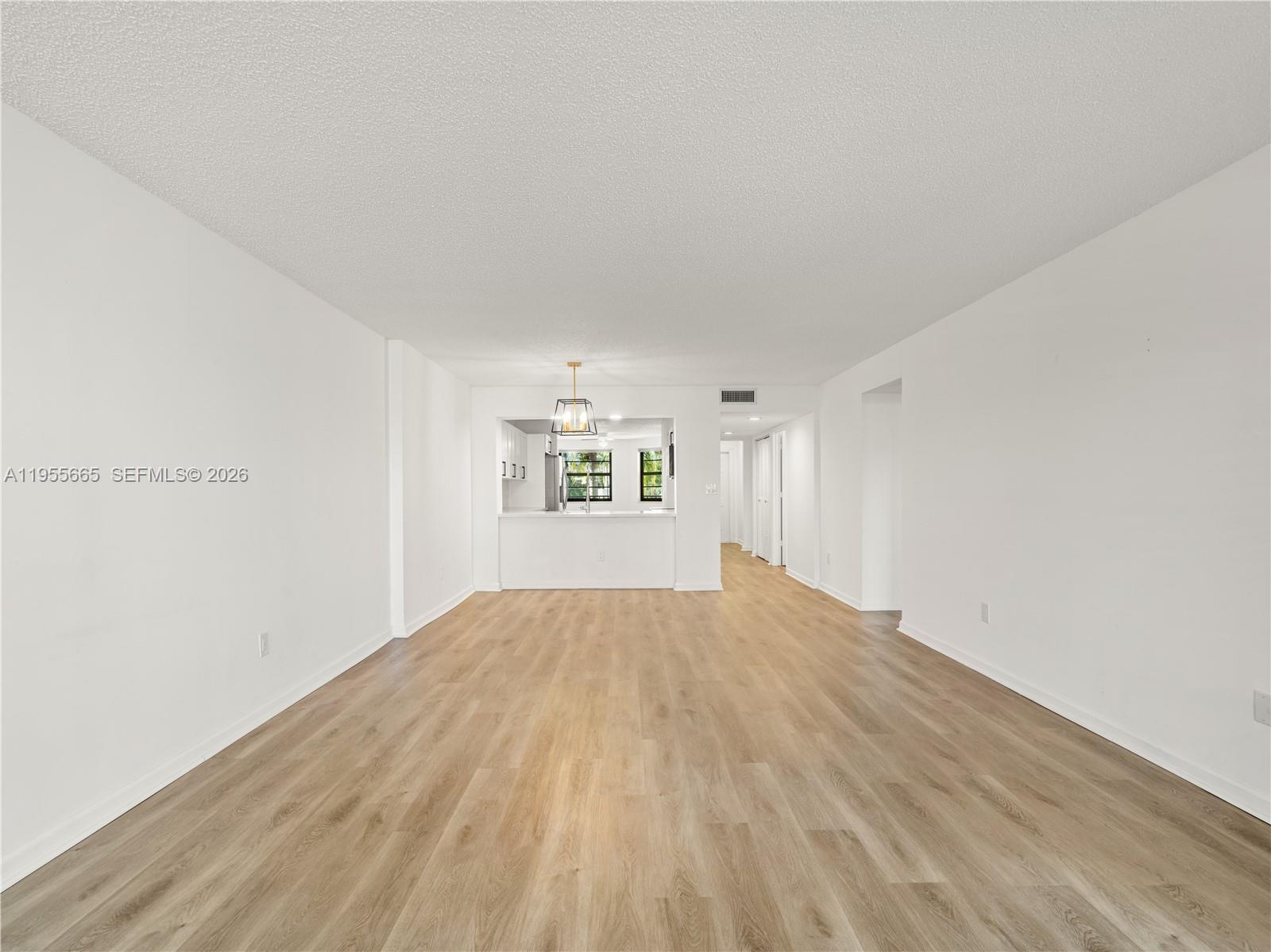 7547 Fairfax Drive, Unit 210 Tamarac, FL 33321 - Photo 7 of 38 a view of empty room with wooden floor and fan