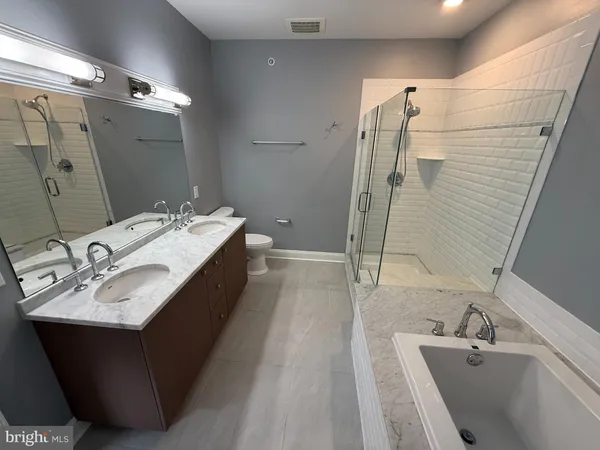 a en suite bathroom with a double vanity sink a mirror and shower