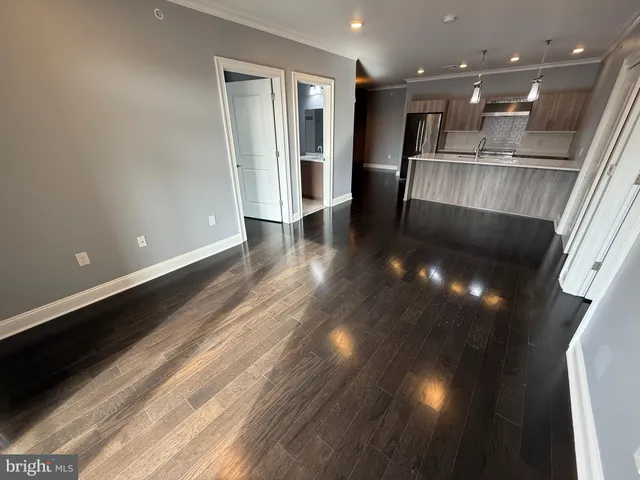 a view of a hallway with wooden floor and seating space