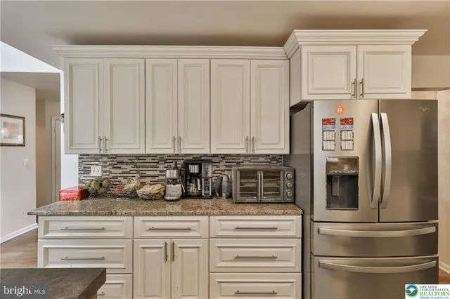 a kitchen with stainless steel appliances granite countertop a stove refrigerator a sink dishwasher with a dining table and chairs