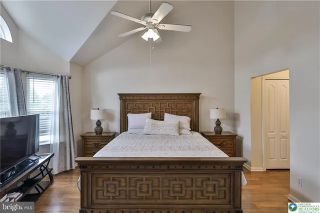 a bedroom with a bed and a flat tv screen on dresser