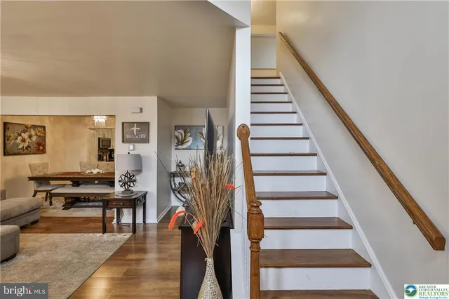 a living room with furniture a chandelier and a large mirror next to a window
