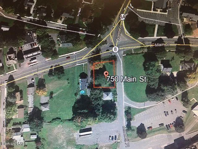 a view of grassy field with benches and trees