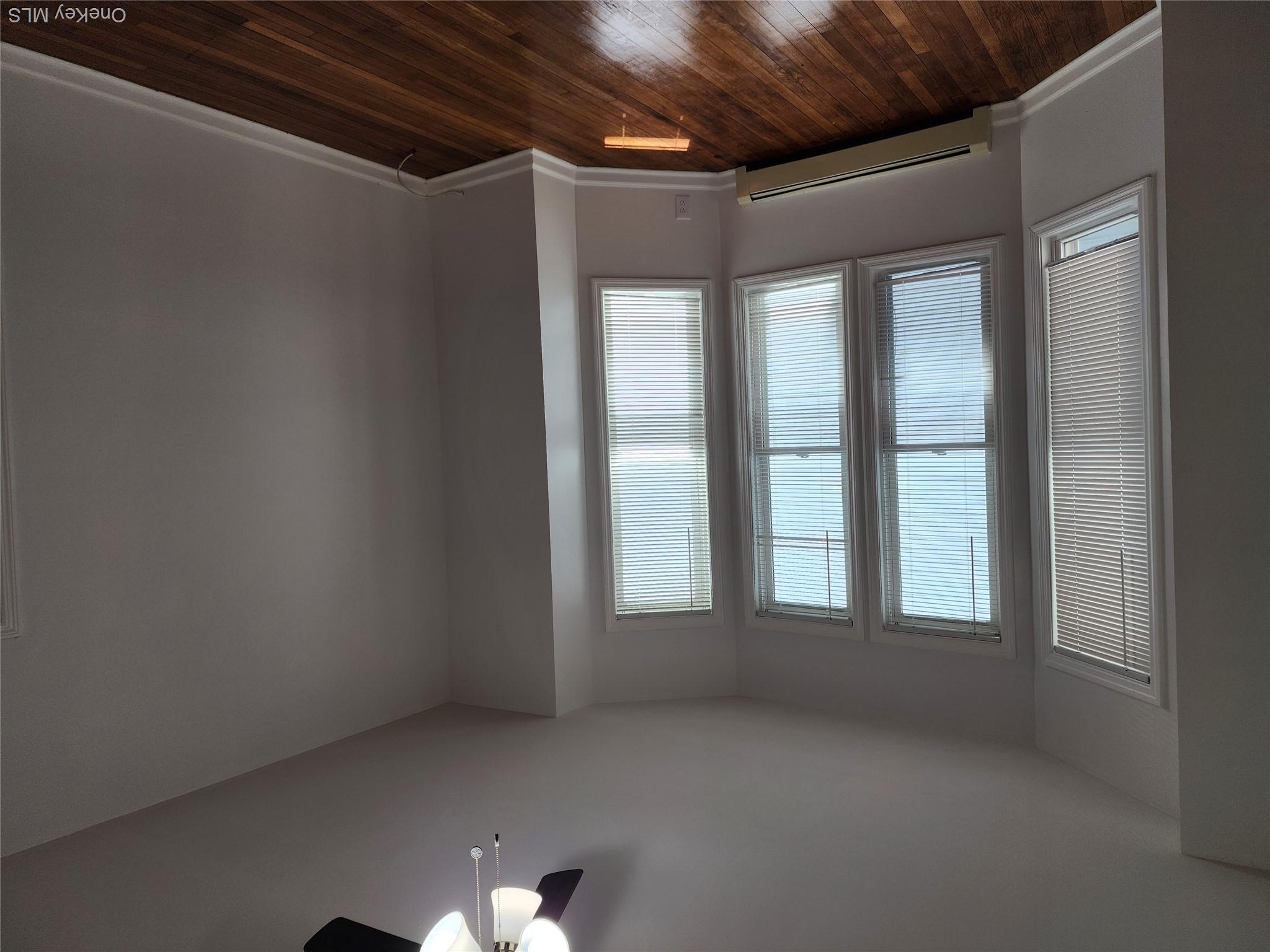 49 Carroll Street, Unit 1 Poughkeepsie, NY 12601 - Photo 7 of 15 an empty room with wooden floor chandelier fan and windows