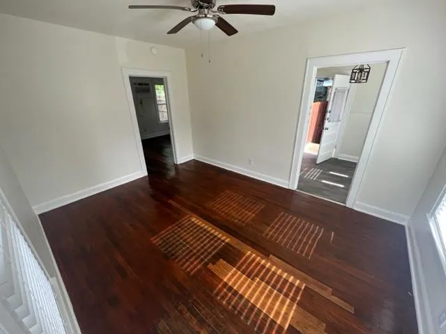 a view of an empty room with wooden floor