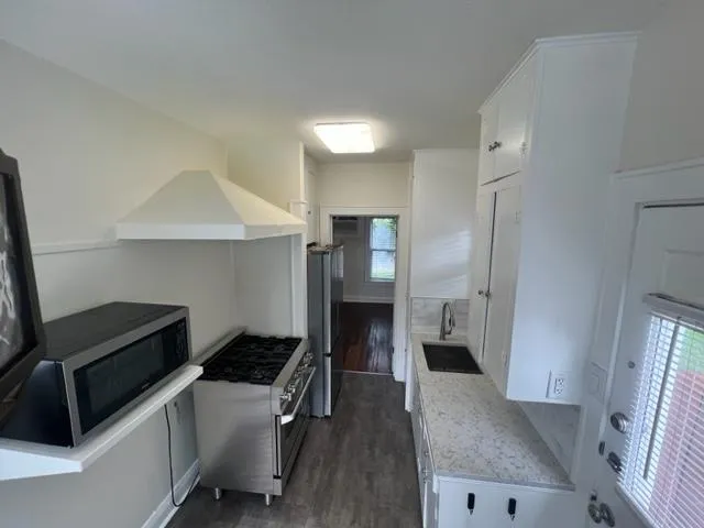 a kitchen with a refrigerator and a stove top oven