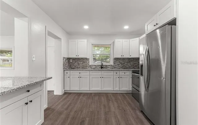 a kitchen with a refrigerator a sink and wooden cabinets