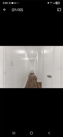 an empty room with wooden floor and ceiling fan