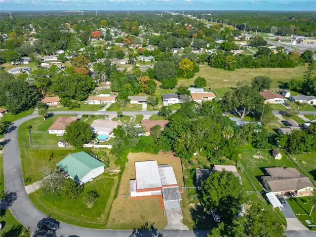 an aerial view of residential houses with outdoor space and trees