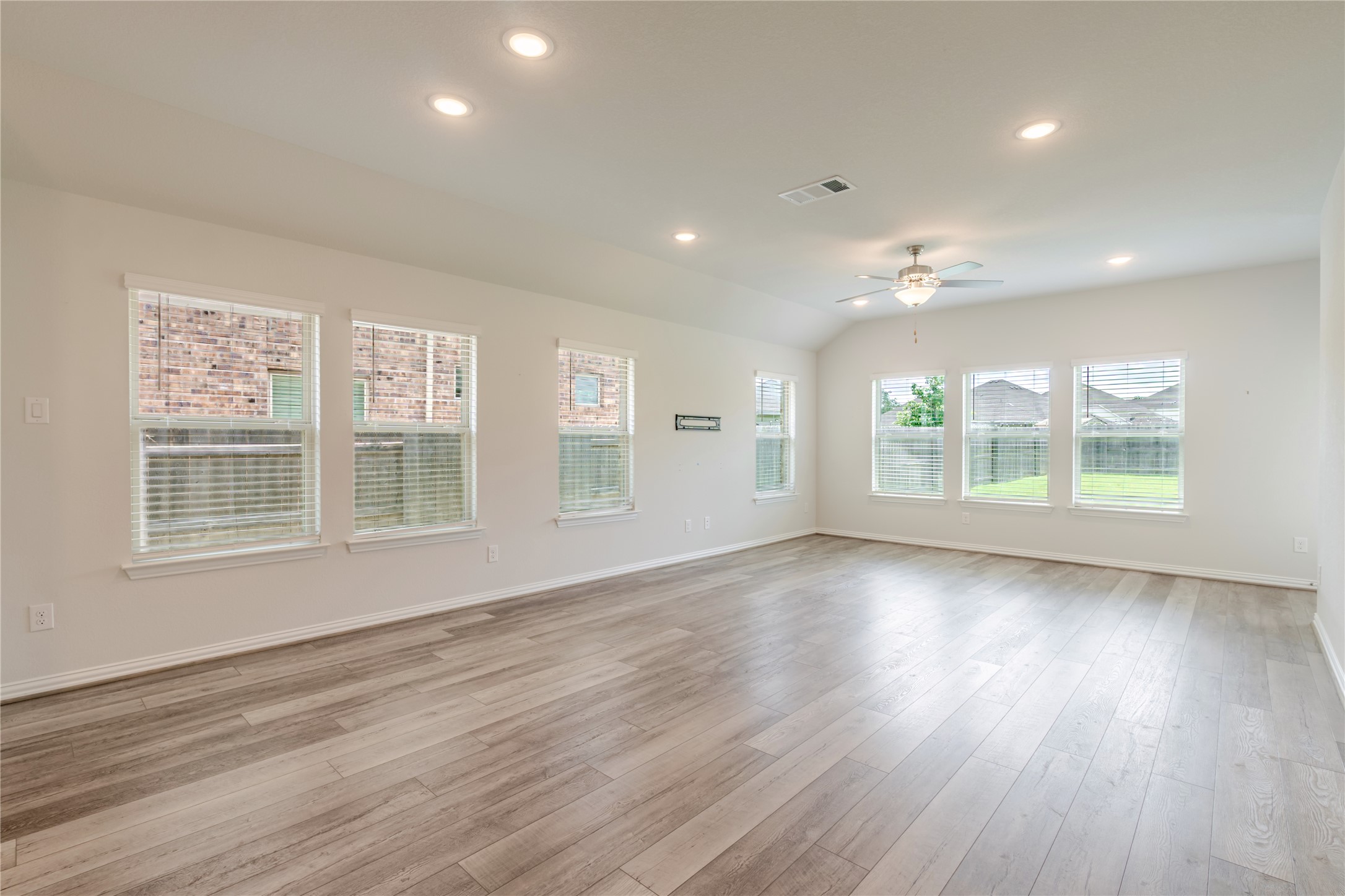1117 Terrace View Georgetown, TX 78628 - Photo 14 of 25 Spacious room featuring wood-finish flooring, recessed lighting, and multiple windows with blinds