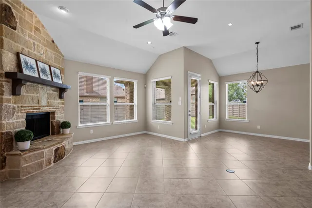 a view of an empty room with a fireplace and a window