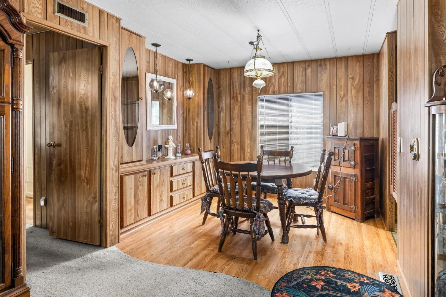 1200 South Carpenter Road, Unit 4 Modesto, CA 95351 - Photo 10 of 31 Dining area featuring wood-panel walls, wood-finish flooring, and a built-in buffet with storage