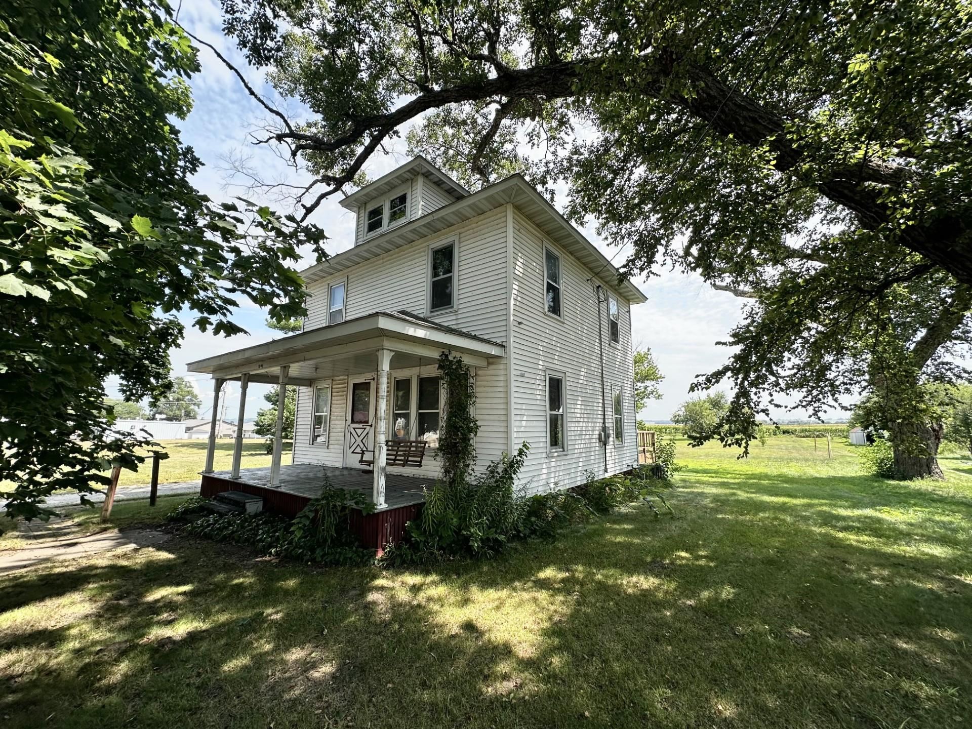 a white house that has tree in front of it