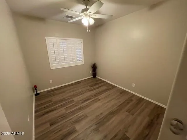 an empty room with windows and fan