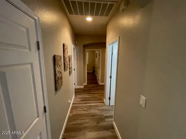 a view of a hallway with wooden floor and staircase