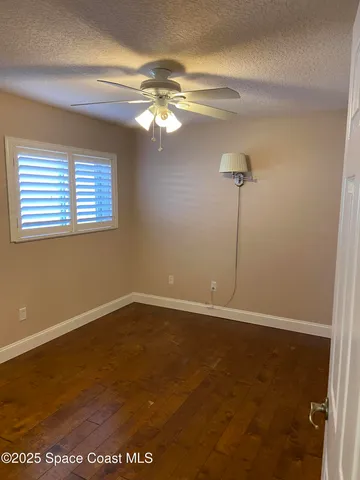 a view of an empty room with a chandelier fan