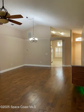 a view of a livingroom with a ceiling fan window and wooden floor