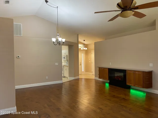 a view of a livingroom with wooden floor and a ceiling fan