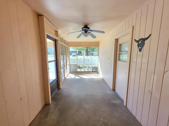 a view of a room with a ceiling fan and windows