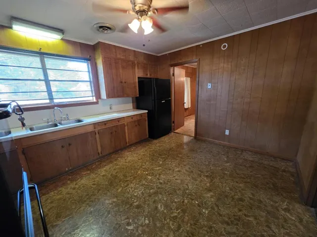 a large kitchen with a large window appliances and cabinets