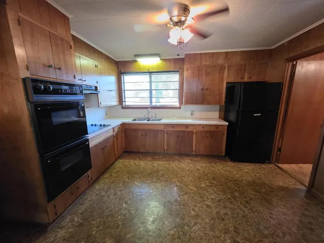 a kitchen with granite countertop a refrigerator and a sink