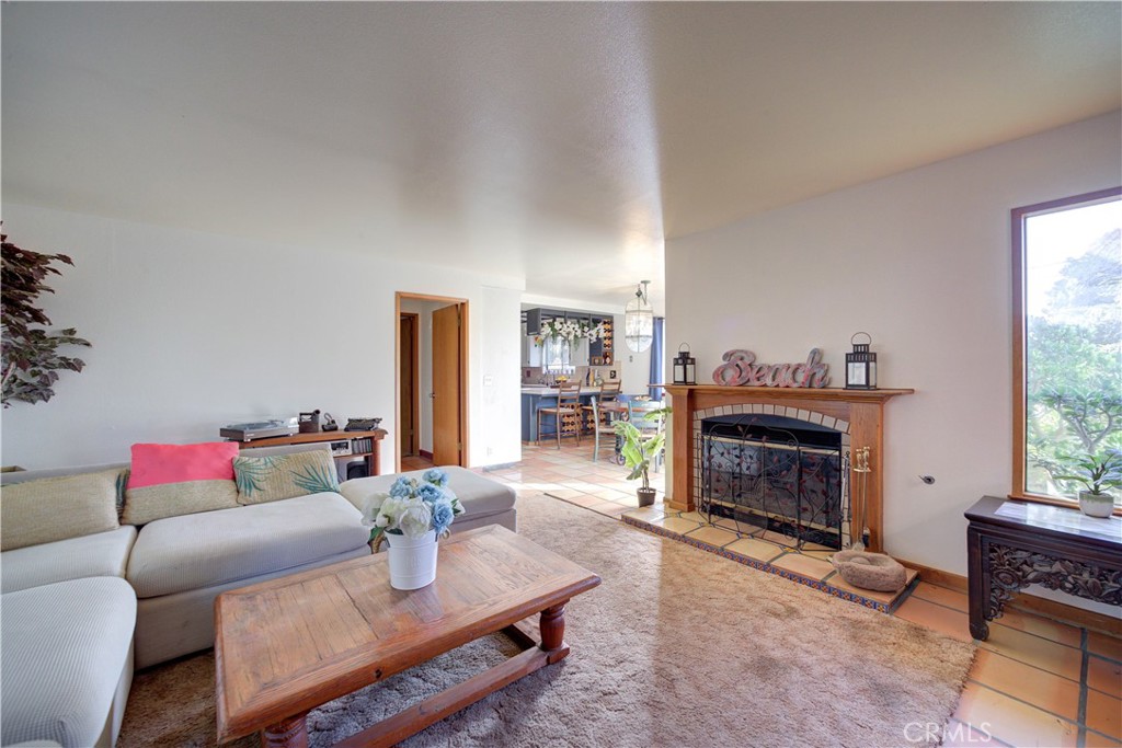 a living room with furniture a fireplace and a floor to ceiling window