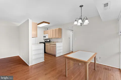 a kitchen with a refrigerator a stove cabinets and wooden floor
