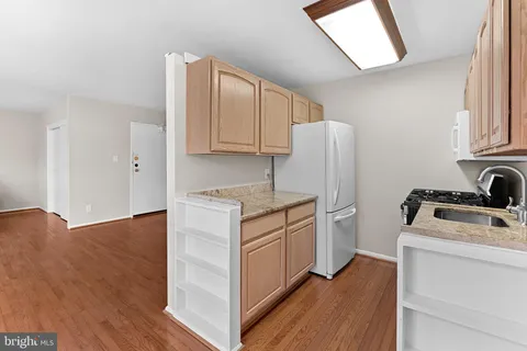 a kitchen with a refrigerator sink and cabinets