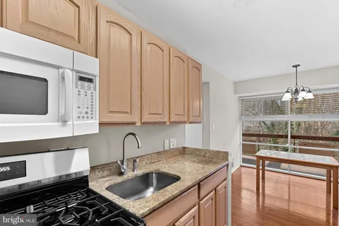 a kitchen with kitchen island granite countertop a sink stainless steel appliances and cabinets