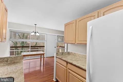 a kitchen with granite countertop a refrigerator and cabinets