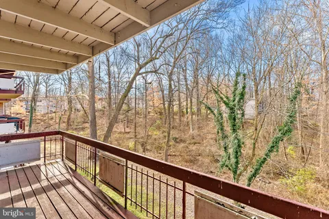 a view of balcony with wooden floor and fence