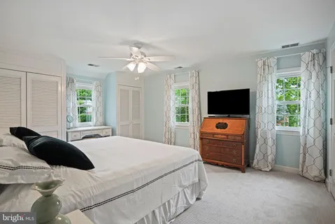 a bedroom with a bed flat screen tv and a window