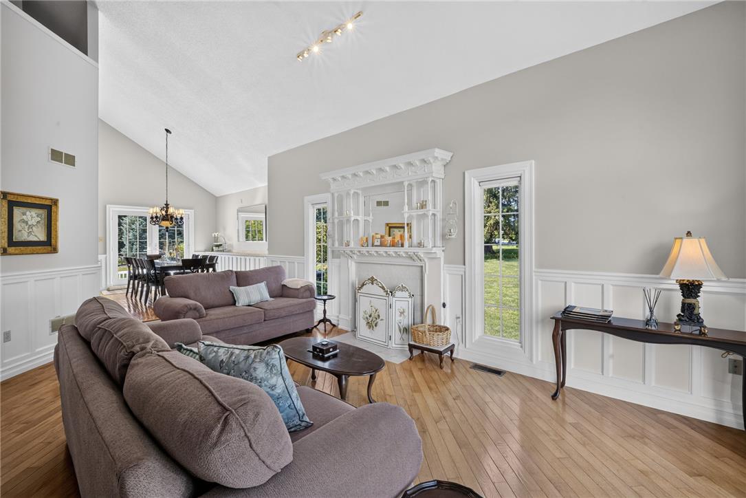 6467 Abbey Road Wind Gap, PA 18091 - Photo 9 of 46 Natural light bathes this comfortable living space, featuring a stately fireplace, lustrous wood flooring, and elegant wainscoting.