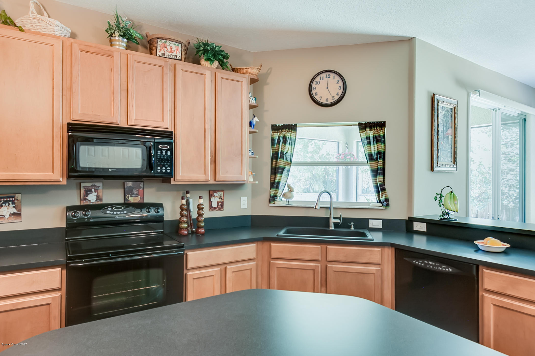 3330 Carter Road Mims, FL 32754 - Photo 11 of 37 a kitchen with granite countertop a sink stove and cabinets