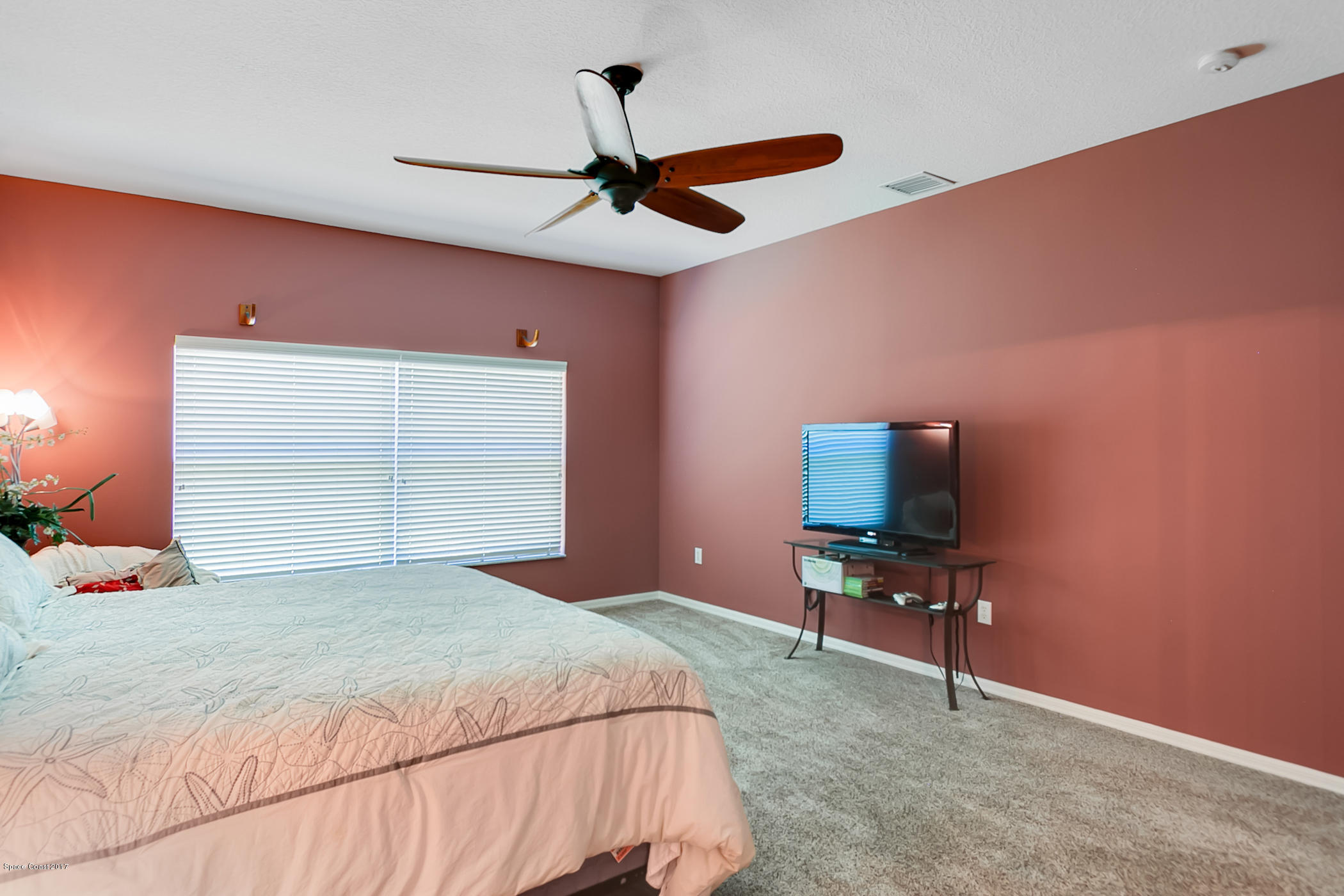 3330 Carter Road Mims, FL 32754 - Photo 21 of 37 a bedroom with a bed and a flat tv screen on dresser