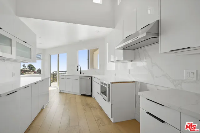a kitchen with white cabinets and white appliances
