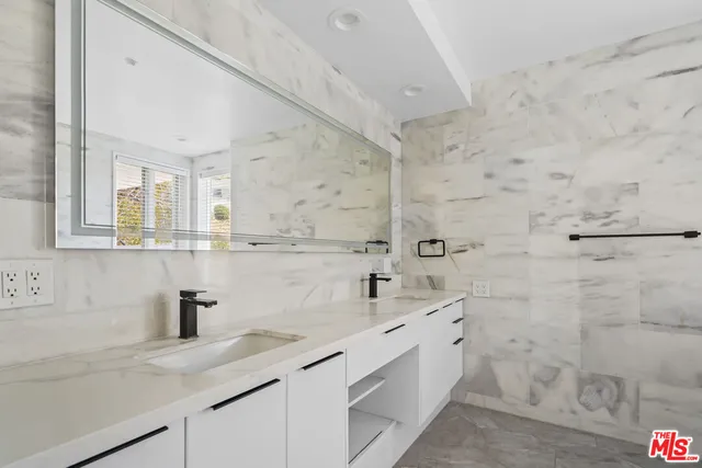 a bathroom with a sink a mirror and shower