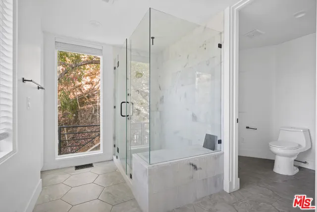 a bathroom with a tub shower and toilet