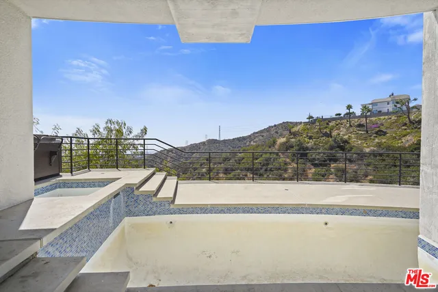 a view of roof with furniture and city view