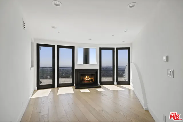 wooden floor fireplace and windows in an empty room