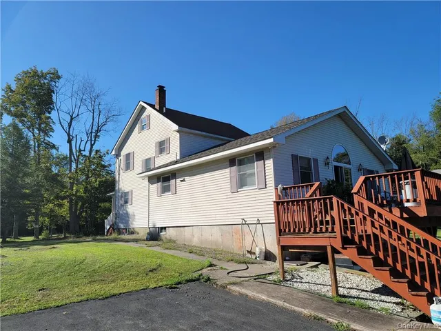 a view of a house with a yard and wooden fence