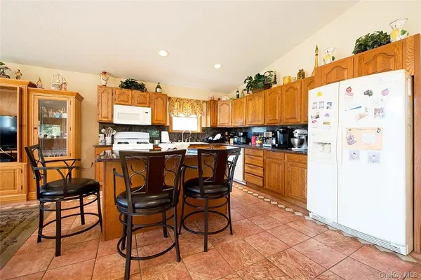 a kitchen with stainless steel appliances kitchen island granite countertop a refrigerator and microwave