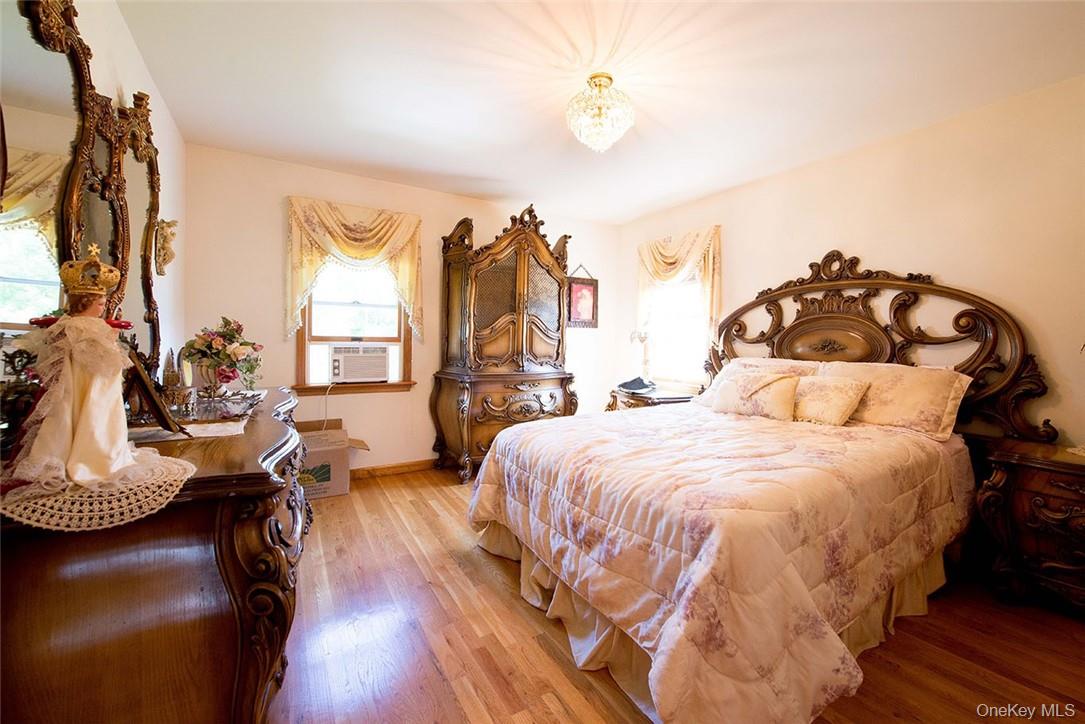 114 Levine Road Kiamesha Lake, NY 12751 - Photo 28 of 36 a spacious bedroom with a bed and a chandelier