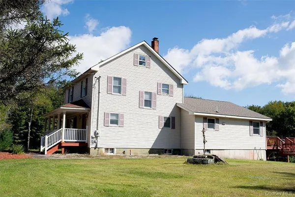 a front view of a house with a yard and trees