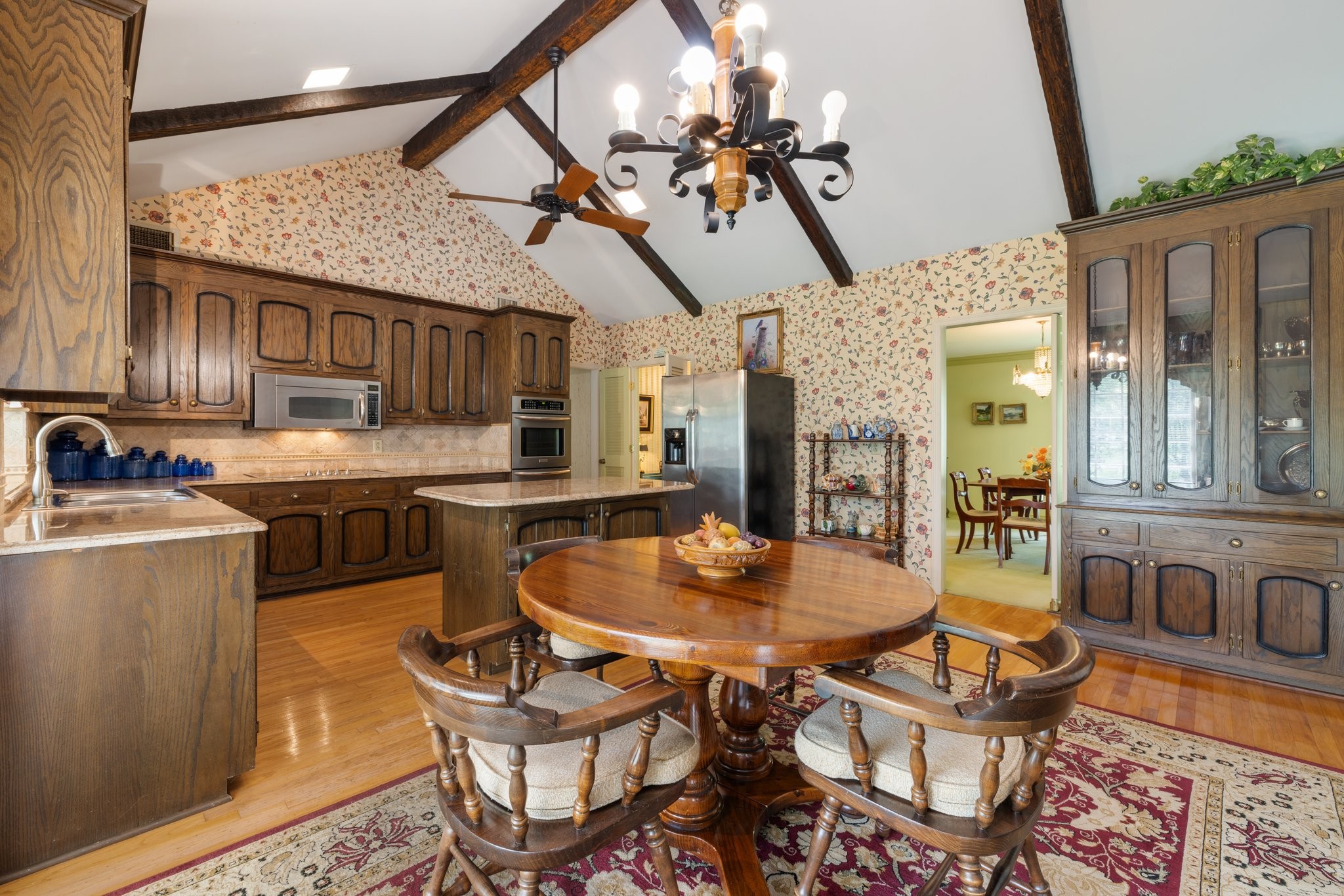 1409 Sneed Road West Franklin, TN 37069 - Photo 16 of 47 a open kitchen with stainless steel appliances kitchen island granite countertop a table chairs in it and wooden floors