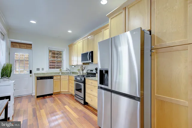 a kitchen with stainless steel appliances a refrigerator sink and microwave